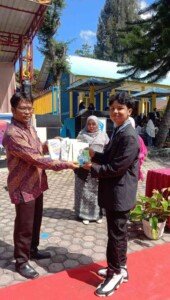 secara simbolis penyerahan buku dari siswa kelas XII kepada Kepala Sekolah SMA Negeri 1 Bukit