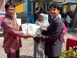 secara simbolis penyerahan buku dari siswa kelas XII kepada Kepala Sekolah SMA Negeri 1 Bukit